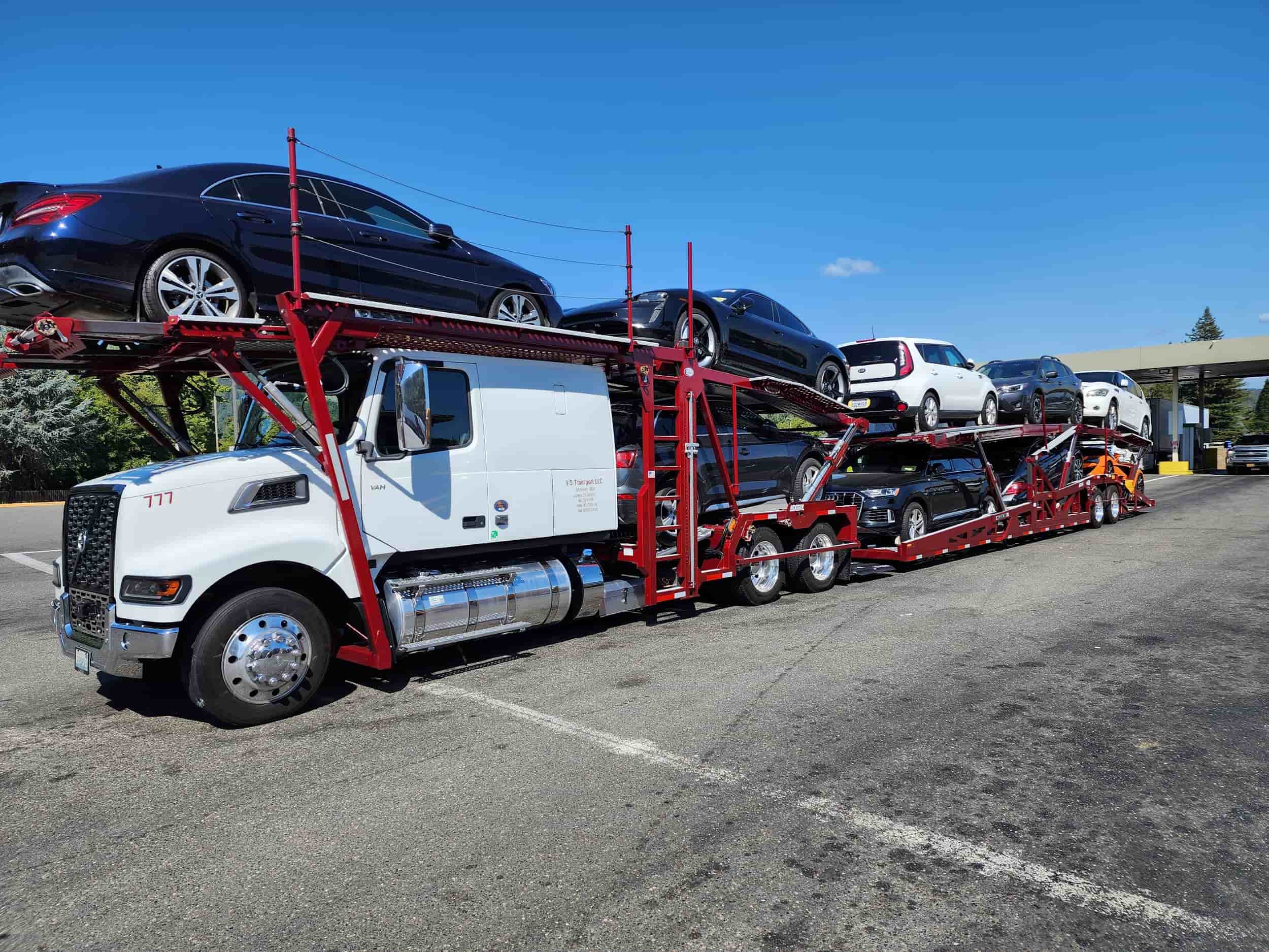 a red open carrier auto transport truck